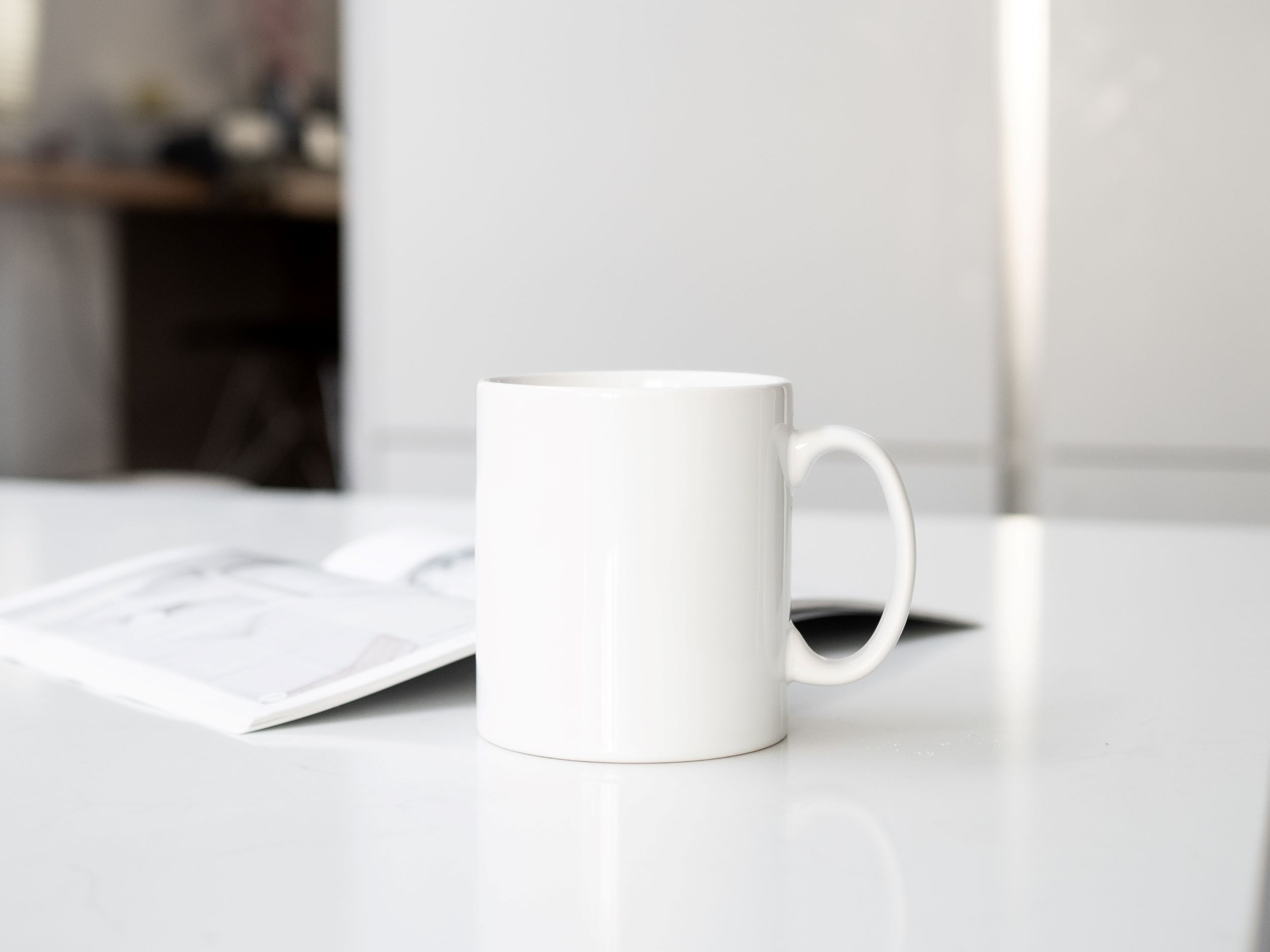 Image showing white coffee mug and open notebook sitting on white table